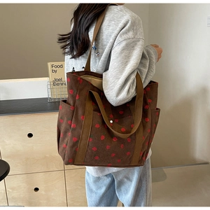 Détail du grand sac cabas en velours côtelé marron avec imprimé fraise et poche latérale