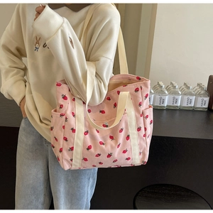 Vue détaillée du sac cabas en velours côtelé rose avec imprimé fraise et anses en toile