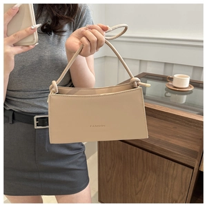 Detail of beige faux leather shoulder bag with knotted strap and FASHION lettering