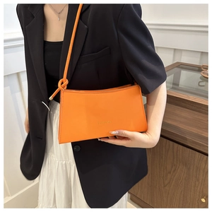 Detailed view of an orange leather fashion shoulder bag with FASHION lettering