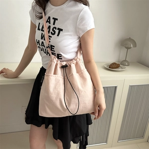 Light pink lightweight nylon bucket bag with adjustable straps and front pockets