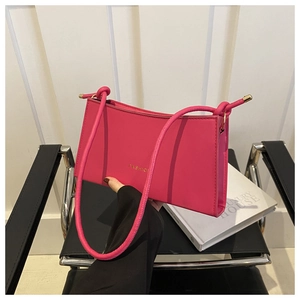 Detail of hot pink baguette bag featuring gold FASHION lettering and smooth leather finish