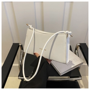 Detail of white rectangular PU leather underarm bag with gold FASHION lettering logo