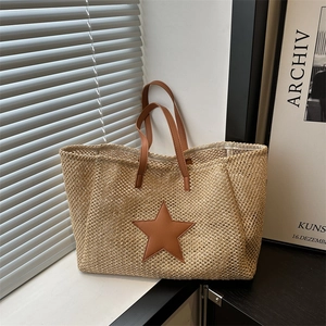 Fashionable straw woven tote bag with brown leather handles and star motif decoration