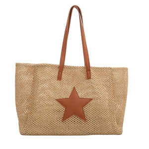 Large woven tote bag with brown leather star patch and long handles on white background