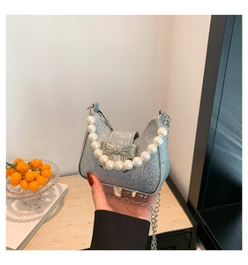 Detailansicht der silbernen Glitzertasche mit Perlengriff und eleganter Metallschleife