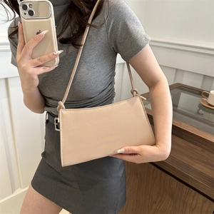 Minimalist beige faux leather baguette shoulder bag with slim strap shown in mirror selfie