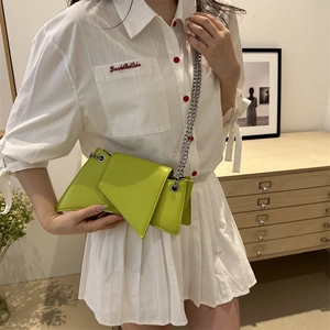 Neon green asymmetrical leather shoulder bag with silver chain strap on model