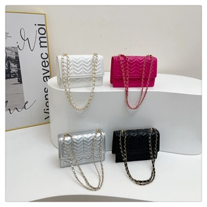 Detailed view of four quilt-textured crossbody bags in white, pink, silver and black