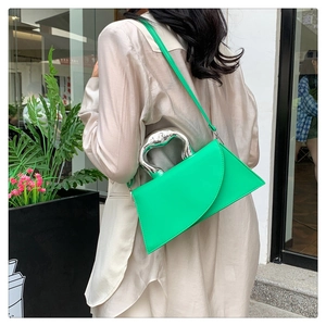 Details der grünen geometrischen Handtasche mit kunstvollem Silbergriff und Lederriemen