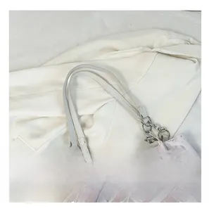 Dettaglio della tracolla in catena e pelle di una borsa tote con stampa farfalle