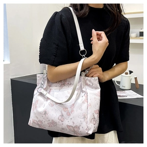 Dettaglio macro della stampa a farfalla su borsa tote con catena in argento decorata