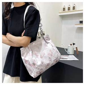 Dettaglio della borsa tote con stampa a farfalla, catene metalliche e stile casual moderno