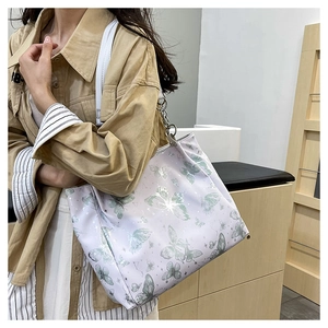 Dettaglio della borsa tote lilla con farfalla, glitter argento e tracolla a catena