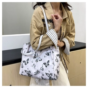 Dettaglio della borsa shopper bianca con stampe a farfalla e spalline sottili