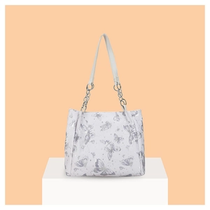 Dettaglio della borsa tote bianca con stampe di farfalle argentate e catena in metallo