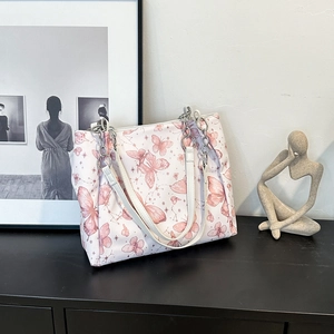 Borsa tote con stampa a farfalla rosa e bianca e catena argentata su fondo nero