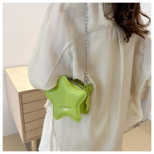 Détail d'un sac bandoulière en forme d'étoile en cuir vert citron avec chaîne argentée