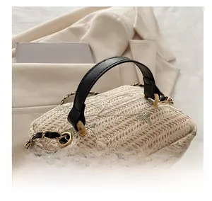 Detail of leaf embroidery on woven bucket bag with leather handle and metal rings