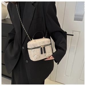 Detailed embroidery of green leaves and white flowers on a beige woven box handbag
