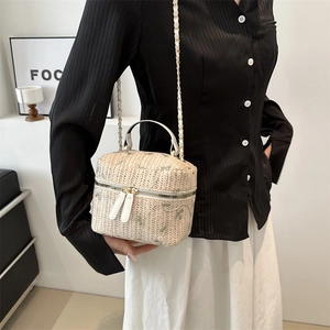 Chic beige straw bucket bag with green leaf embroidery and white leather handles