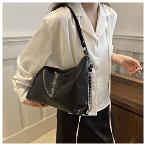 Macro della scritta in rilievo 3D e della trama in pelle su borsa hobo nera alla moda