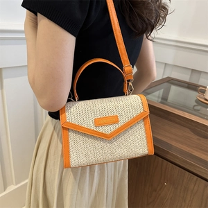 Chic woven handbag with orange leather trim and crossbody strap shown on a model