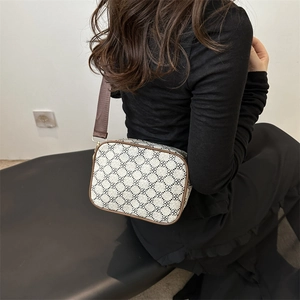 Minimalist beige crossbody bag with black clover pattern and brown shoulder strap