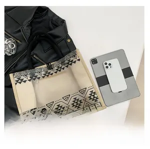 Detailed shot of transparent PVC tote bag with black geometric patterns and woven handles