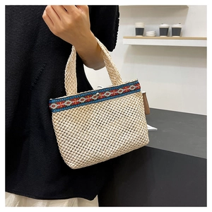 Detail of hand-woven envelope bag featuring ethnic geometric patterns and grid texture