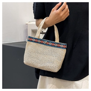 Detail of handwoven summer beach bag with ethnic embroidery and silver snap closure