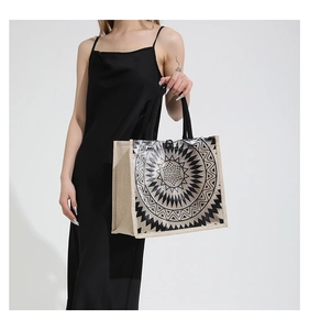 Detail view of large clear PVC tote bag with black geometric sun pattern and linen side panels