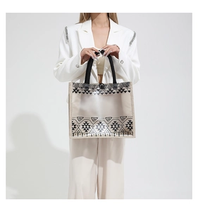 Detail of transparent PVC tote bag with geometric print and woven trim edge