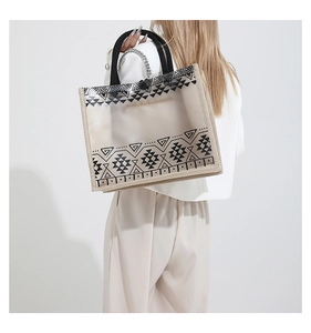 Detailed back view of a transparent PVC tote bag with ethnic patterns and metal chain