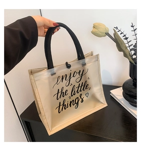 Detail of frosted tote bag with rope handle and 'enjoy the little things' print