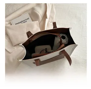 Top-down view showing spacious interior of two-tone tote bag with daily essentials
