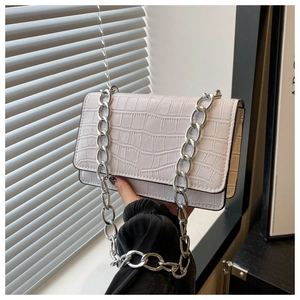 Detail of white croc-embossed small square bag with chunky silver chain strap and flap
