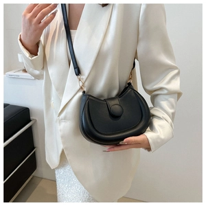 Close-up of a black half-moon saddle bag with matte finish and golden hardware details