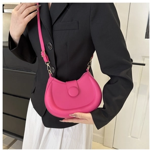 Hot pink saddle bag styled with black blazer and white dress for a chic trendy look