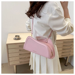 Détail d'un sac bandoulière rose géométrique avec forme irrégulière et fine lanière