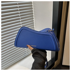 Détail du sac en similicuir bleu roi avec bord ondulé et lettrage doré élégant