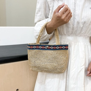 Handwoven straw tote bag with bohemian geometric pattern trim and magnetic closure