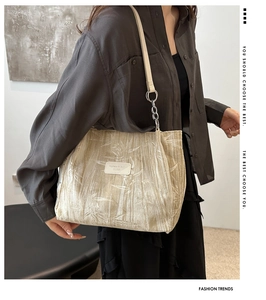 Detail of beige velvet tote bag featuring bamboo leaf embossing and silver metal hardware