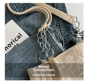Detail of bamboo leaf jacquard texture and silver metal chain links on a chic tote bag