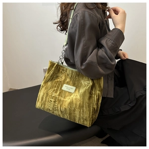 Detail of dark green velvet tote with bamboo leaf embossing and vintage chain strap