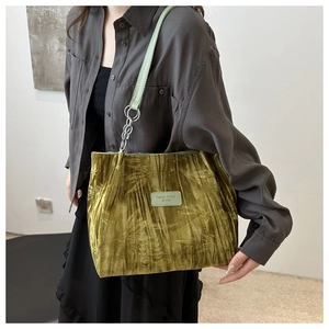 Detail of green bamboo leaf pattern velvet tote with adjustable leather chain strap