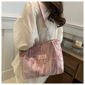 Detail of pink pleated fabric shoulder bag with bamboo print and metal chain strap
