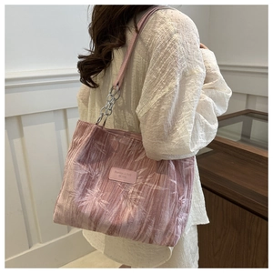 Detail of pink tote bag with white bamboo leaf patterns and silver chain leather strap