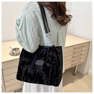 Detail of black velvet tote bag with bamboo leaf pattern and silver chain shoulder strap