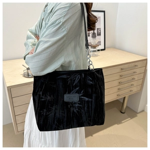 Detail of black velvet tote bag featuring bamboo leaf pattern and silver chain strap